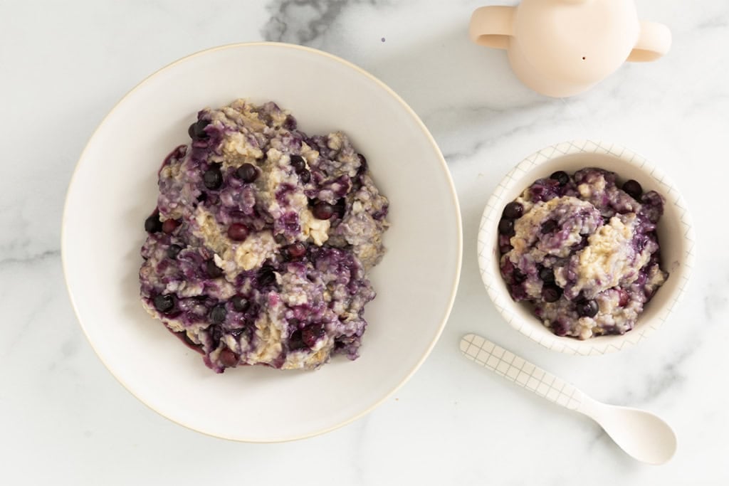 Blueberry oatmeal in two bowls with spoons.