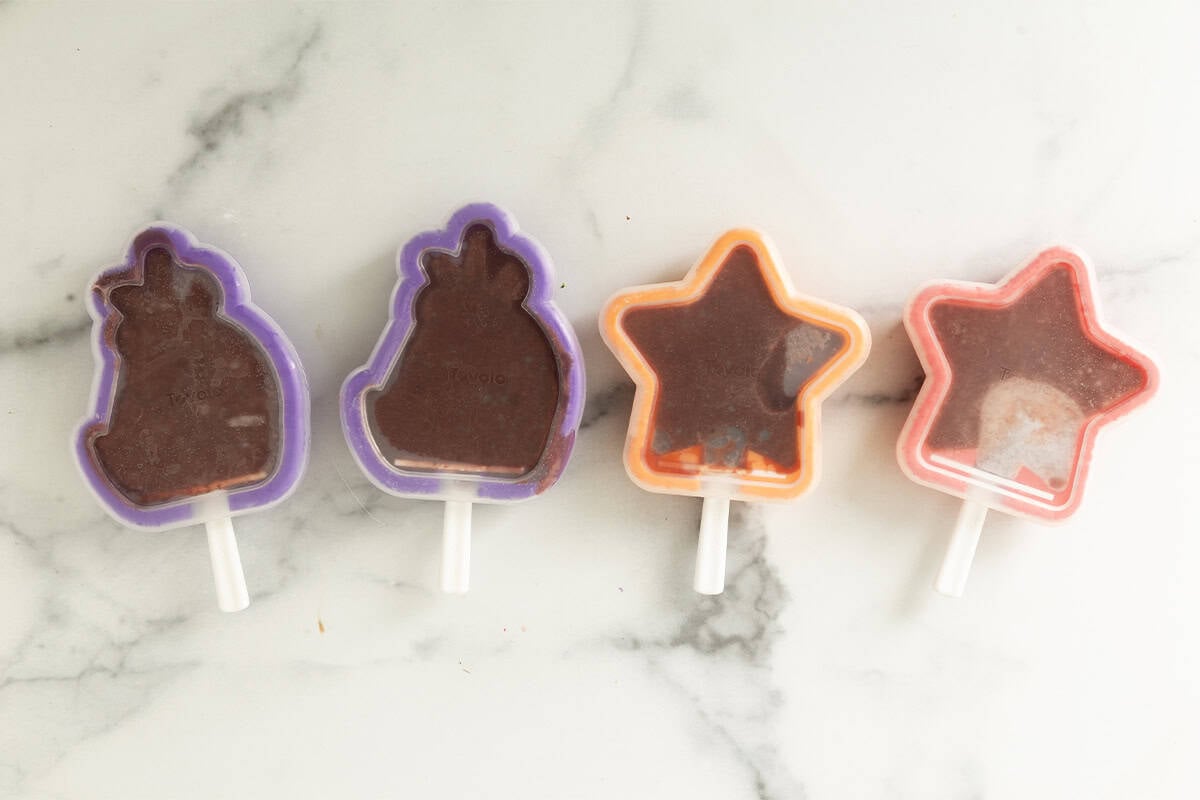 Cherry popsicles in freezer molds before freezing.