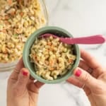 Chicken mac salad in blue bowl with pink spoon.