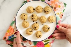Balls of chickpea cookie dough on white plate.