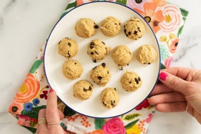 Balls of chickpea cookie dough on white plate.