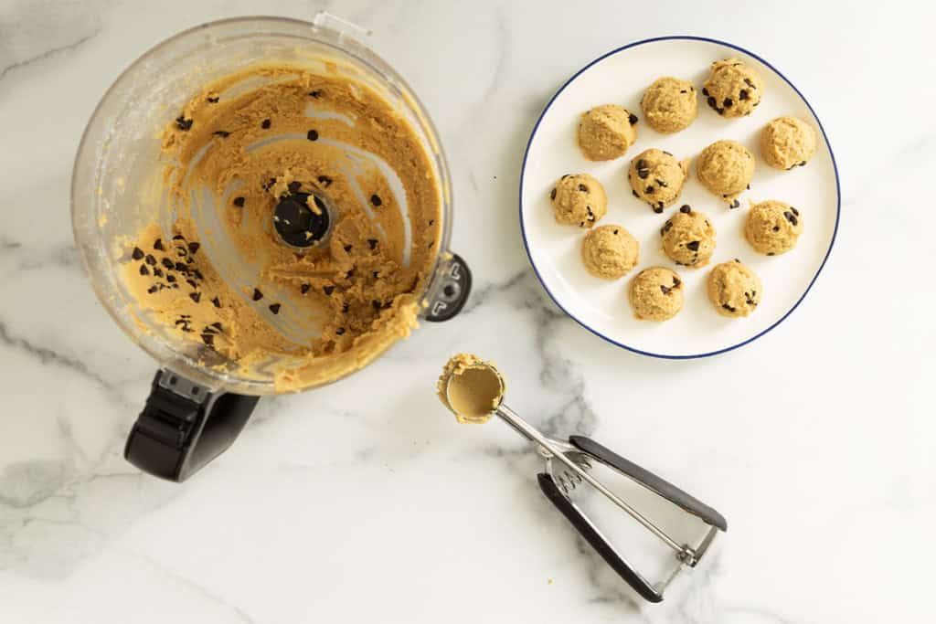 Making balls of chickpea cookie dough with ice cream scoop.