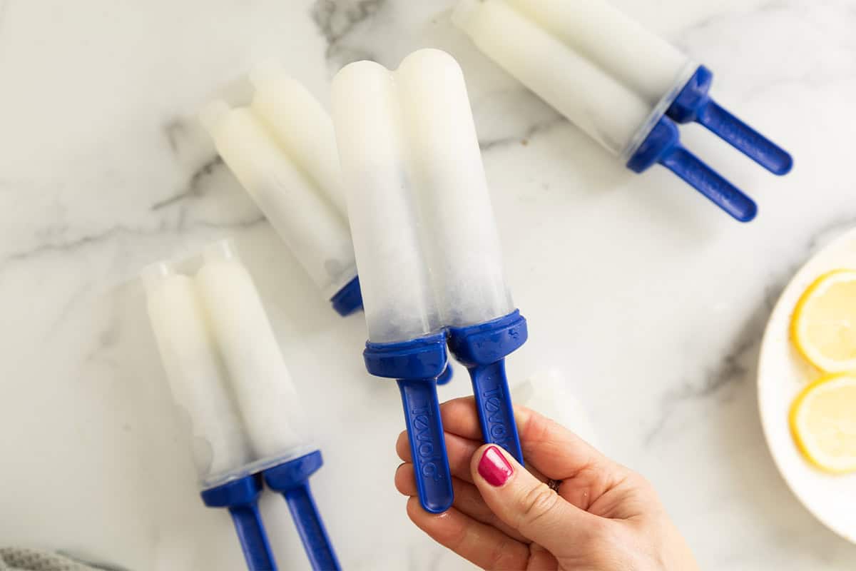 Hand holding lemon popsicle.