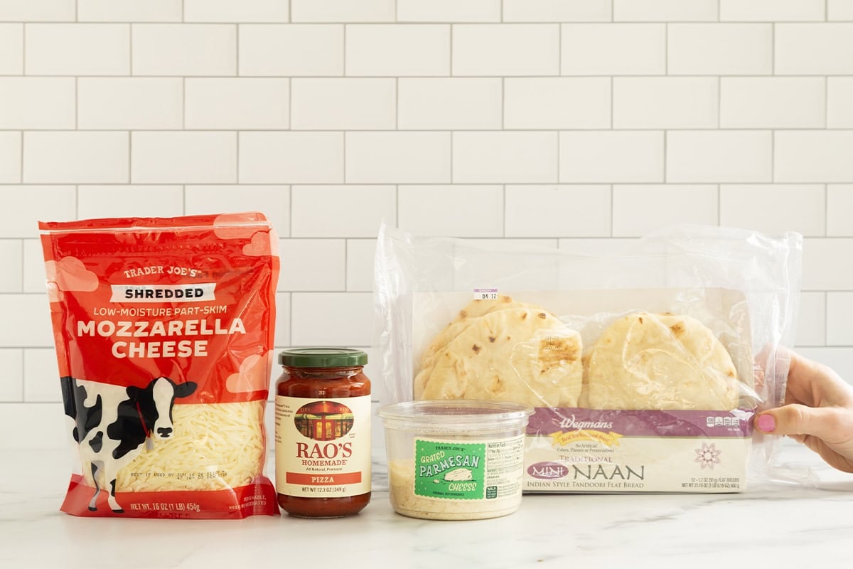 Ingredients for naan pizza on countertop.