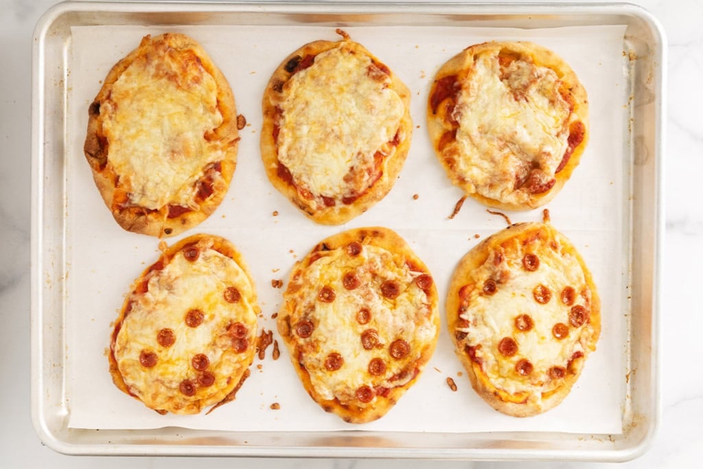 Naan pizza on baking sheet.