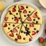 Pancake cake cut into slices on white plate.