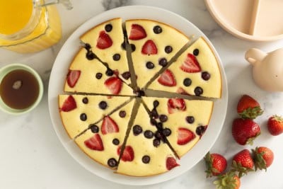 Pancake cake cut into slices on white plate.