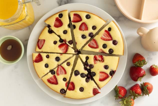 Pancake cake cut into slices on white plate.