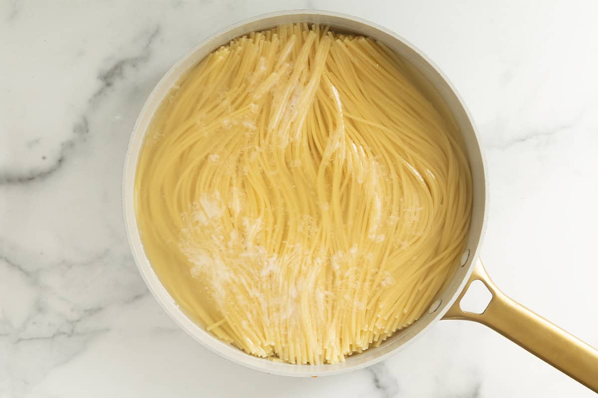 Spaghetti cooking in water for pesto spaghetti.