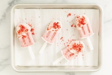 strawberry ice cream bars on parchment paper.