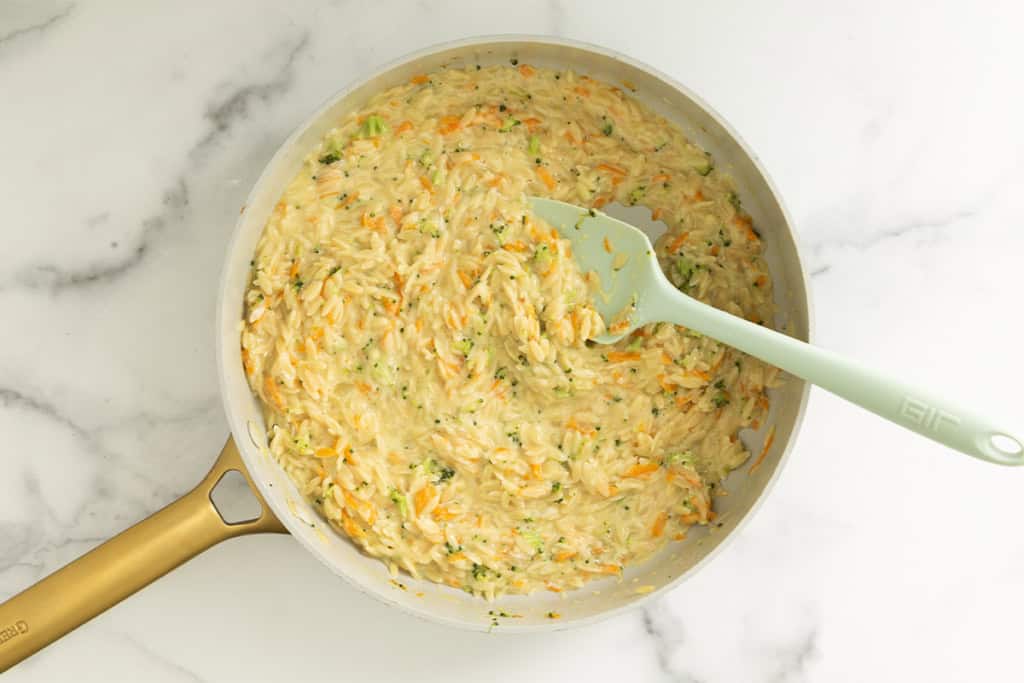 Veggie orzo in pan with spoon.