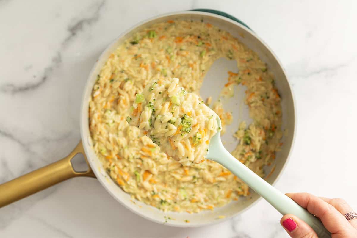 Veggie orzo in pan with spoon.
