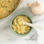 Veggie orzo in blue bowl with spoon.