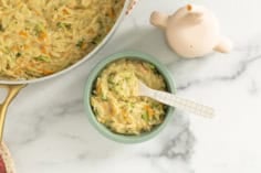 Veggie orzo in blue bowl with spoon.