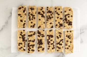 Chewy Chocolate Chip Granola Bars cut into bars on parchment paper.