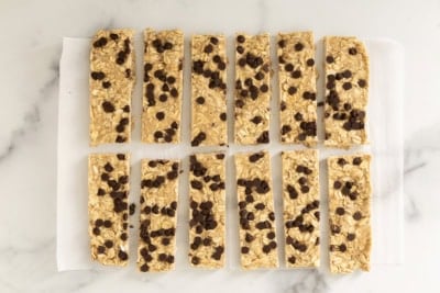Chewy Chocolate Chip Granola Bars cut into bars on parchment paper.