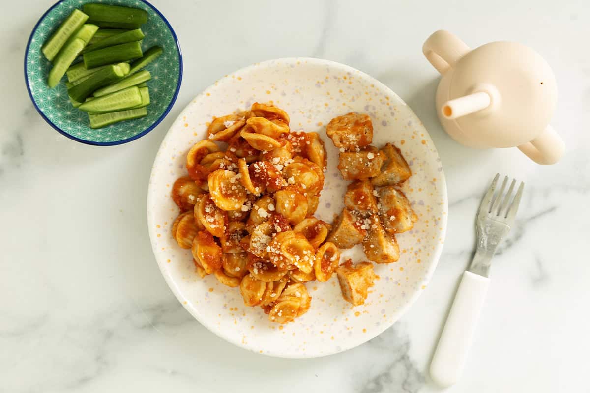 Chicken meatball pasta on white plate.