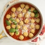 Chicken parmesan meatballs in pan with tomato sauce.