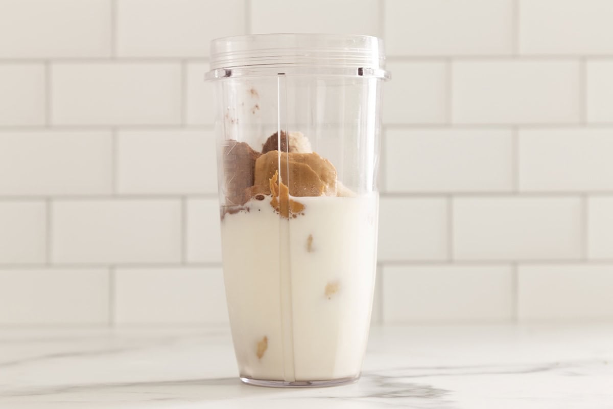 Ingredients for chocolate pb banana smoothie in blender.