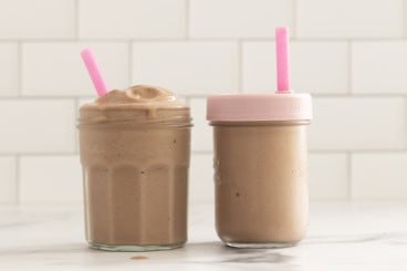 Chocolate peanut butter banana smoothie in two cups with straws.