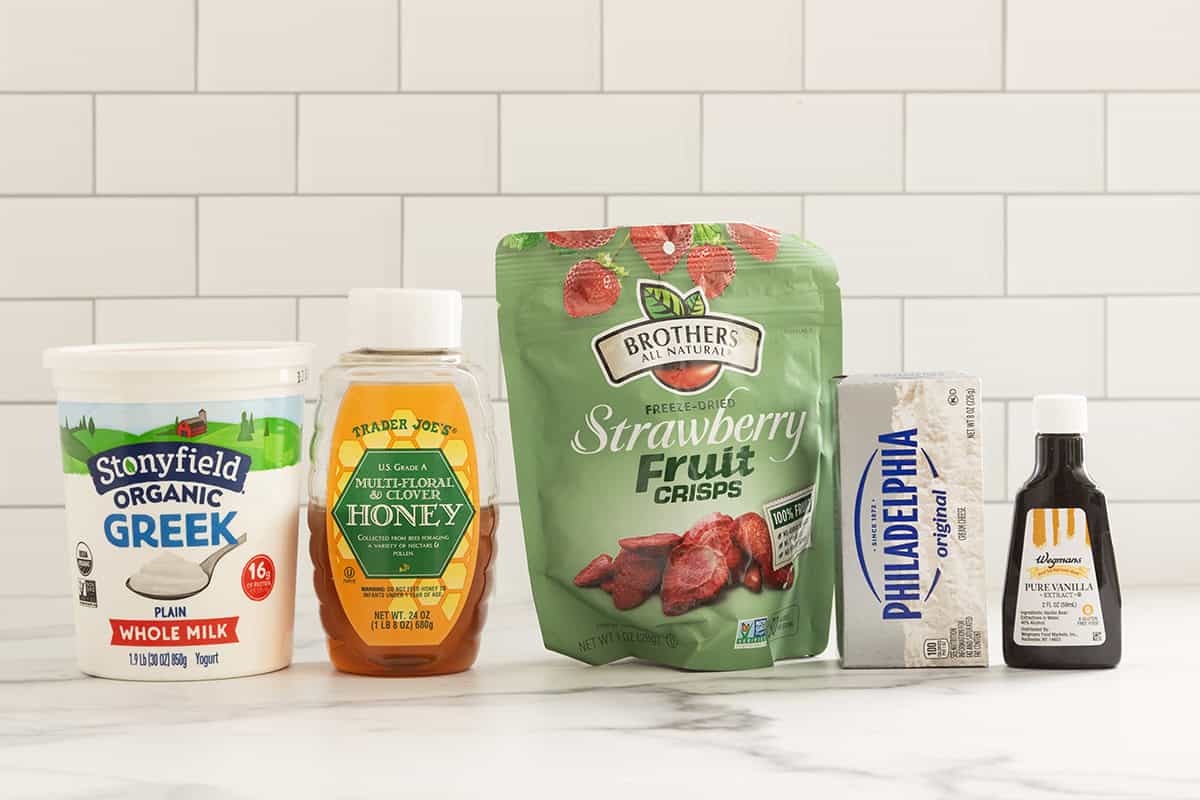 Ingredients for strawberry cheesecake ice cream on countertop.