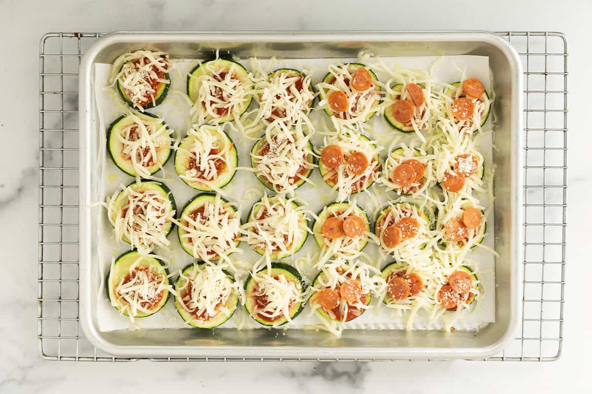 zucchini slices with toppings for zucchini pizza bites before baking.