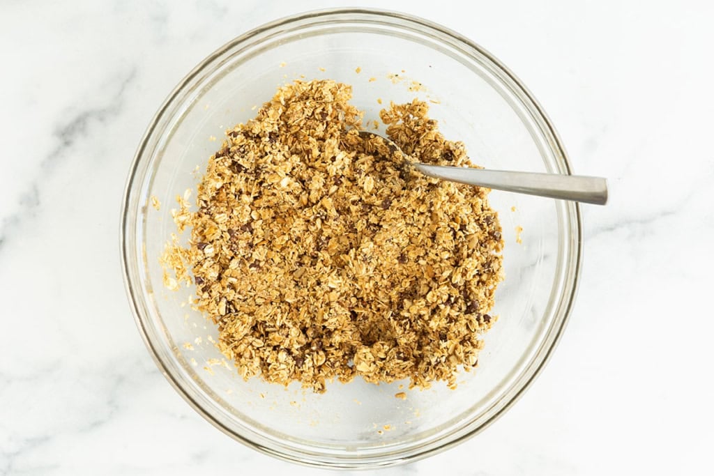 Granola mixture in glass bowl for Chewy Chocolate Chip Granola Bars.