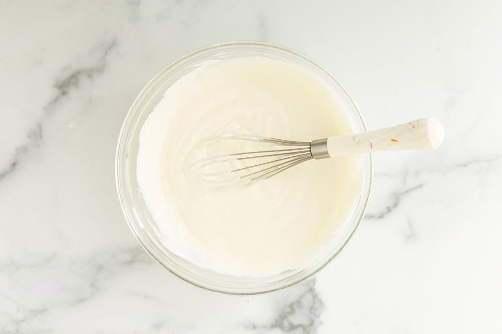 Cream in bowl for strawberry cheesecake ice cream.