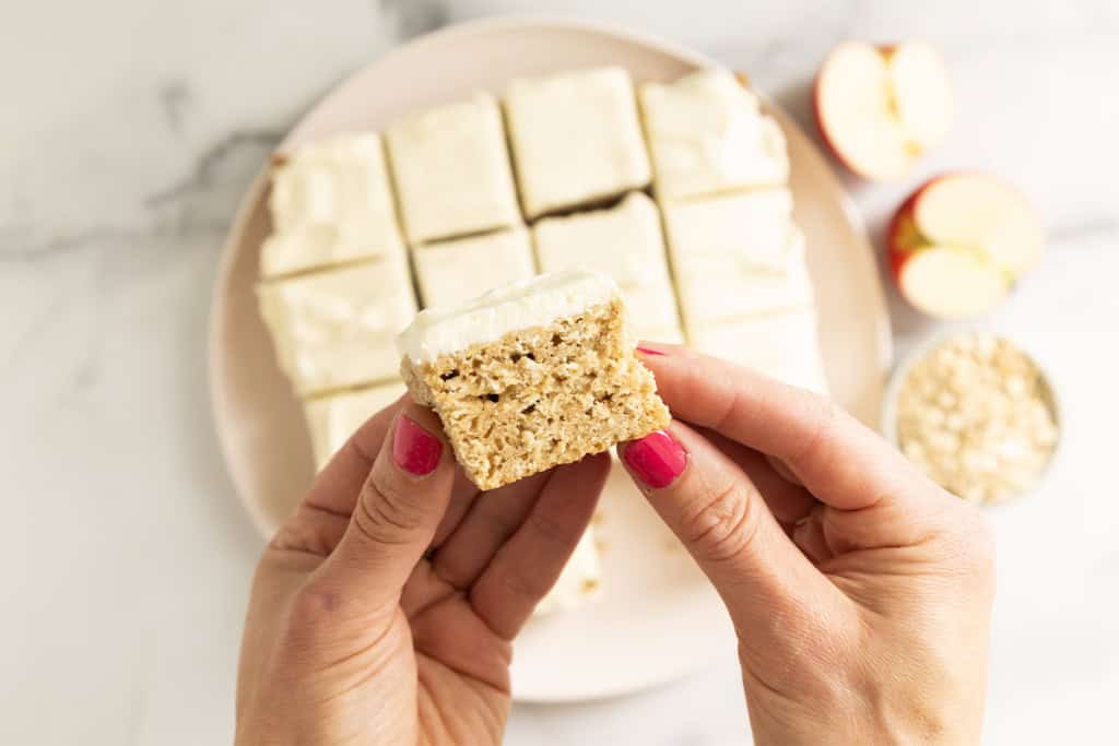 Apple oatmeal cake with hands holding piece.