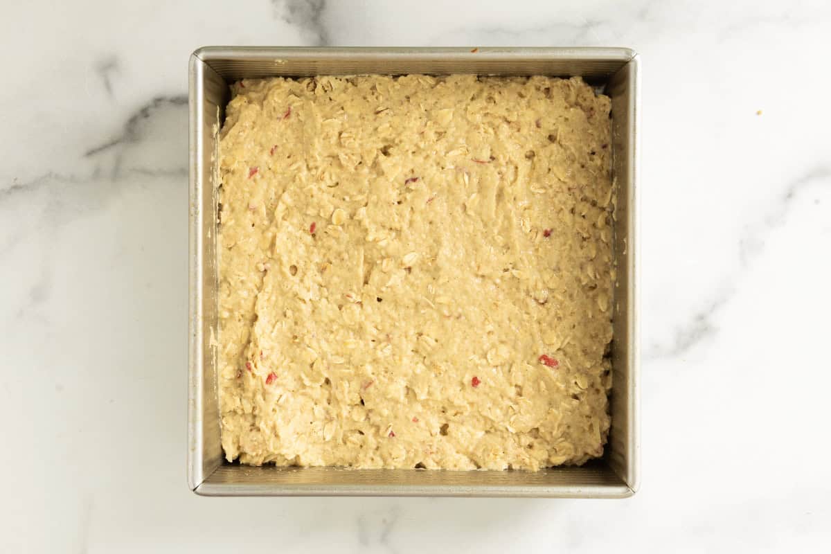 Apple oatmeal cake in baking pan before baking.