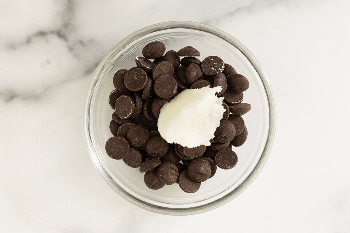 Ingredients for magic chocolate shell in glass bowl before melting.