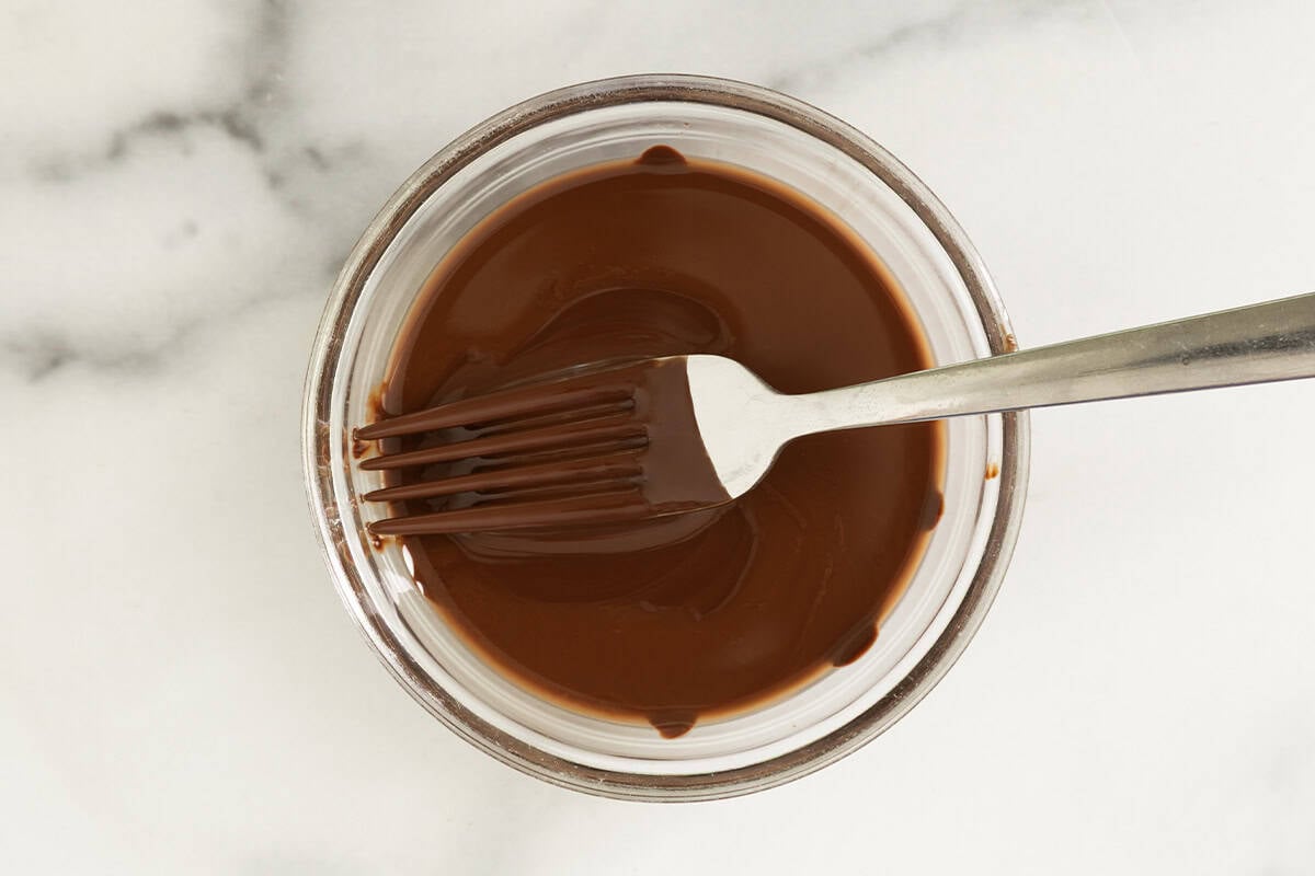 Melted magic chocolate shell in bowl with fork.