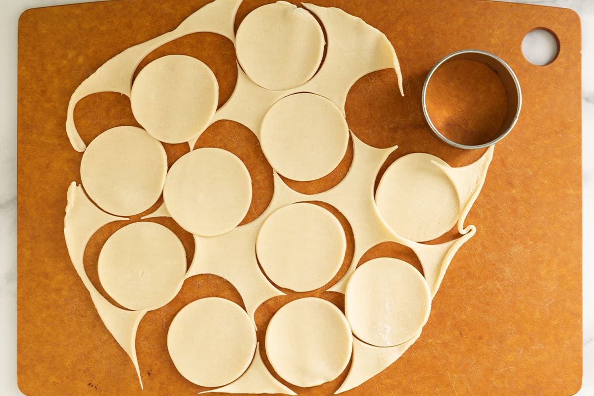 Cutting circles in pie dough for mini apple pies.