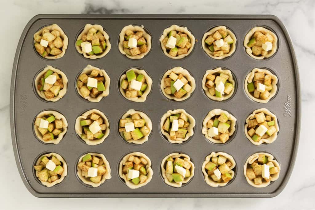 Making mini apple pies in mini muffin pan.