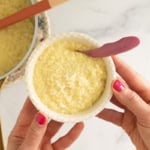 Hands holding bowl of pastina with egg.