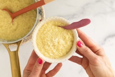 Hands holding bowl of pastina with egg.