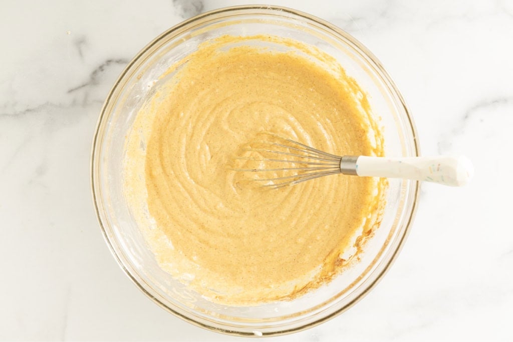 Batter for pumpkin waffles in glass bowl.