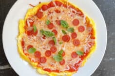 pizza eggs on white plate.