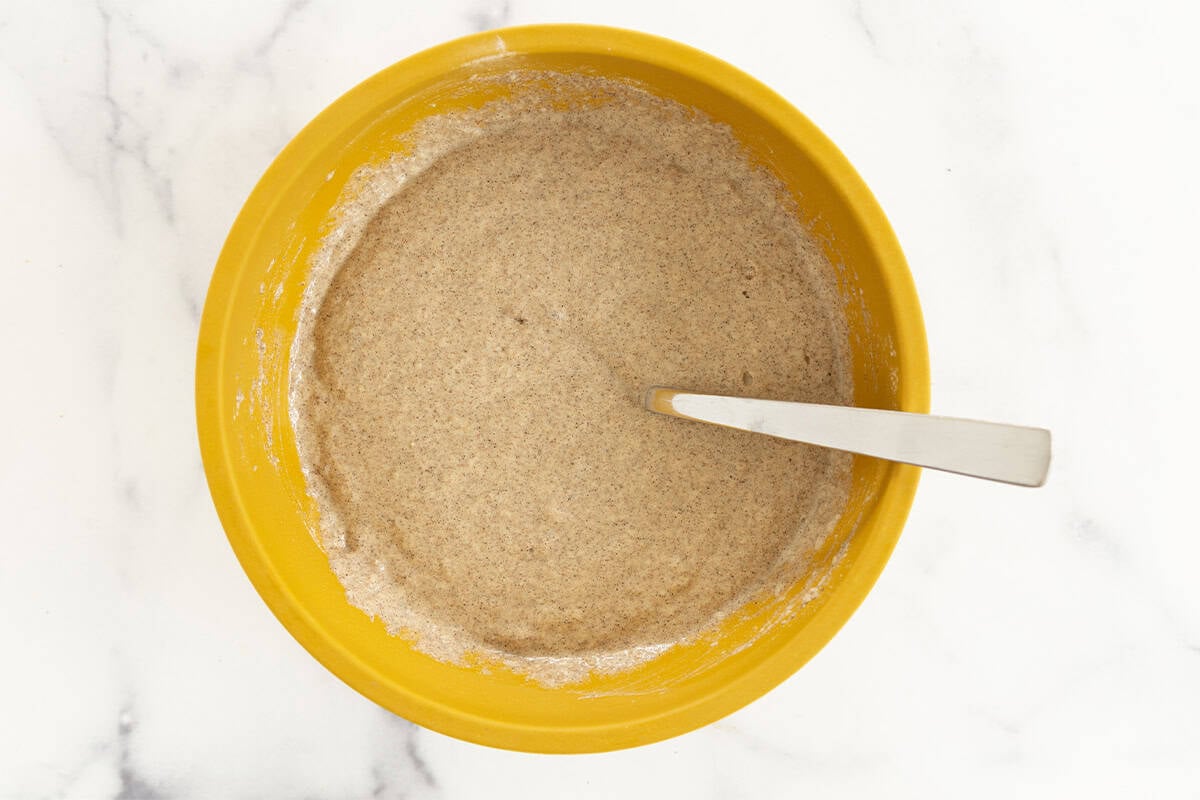Applesauce pancake batter mixed in a yellow bowl.