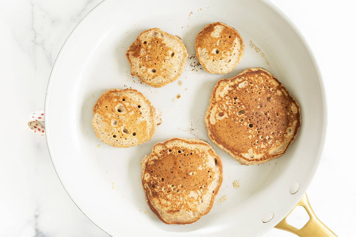 Cooked applesauce pancakes in a skillet.