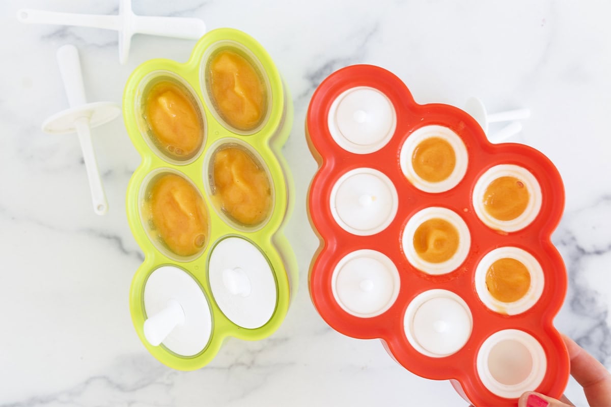 Filled popsicle molds on a counter.