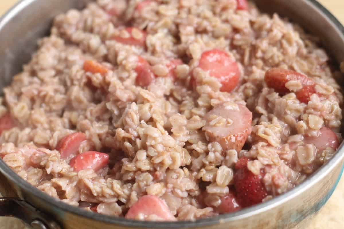 Cooked strawberry oatmeal in a pot.