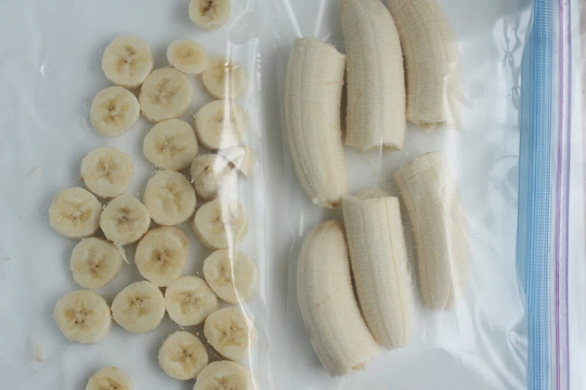Freezer bags filled with sliced and halved bananas.