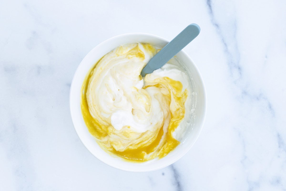 Mango puree stirred into yogurt.
