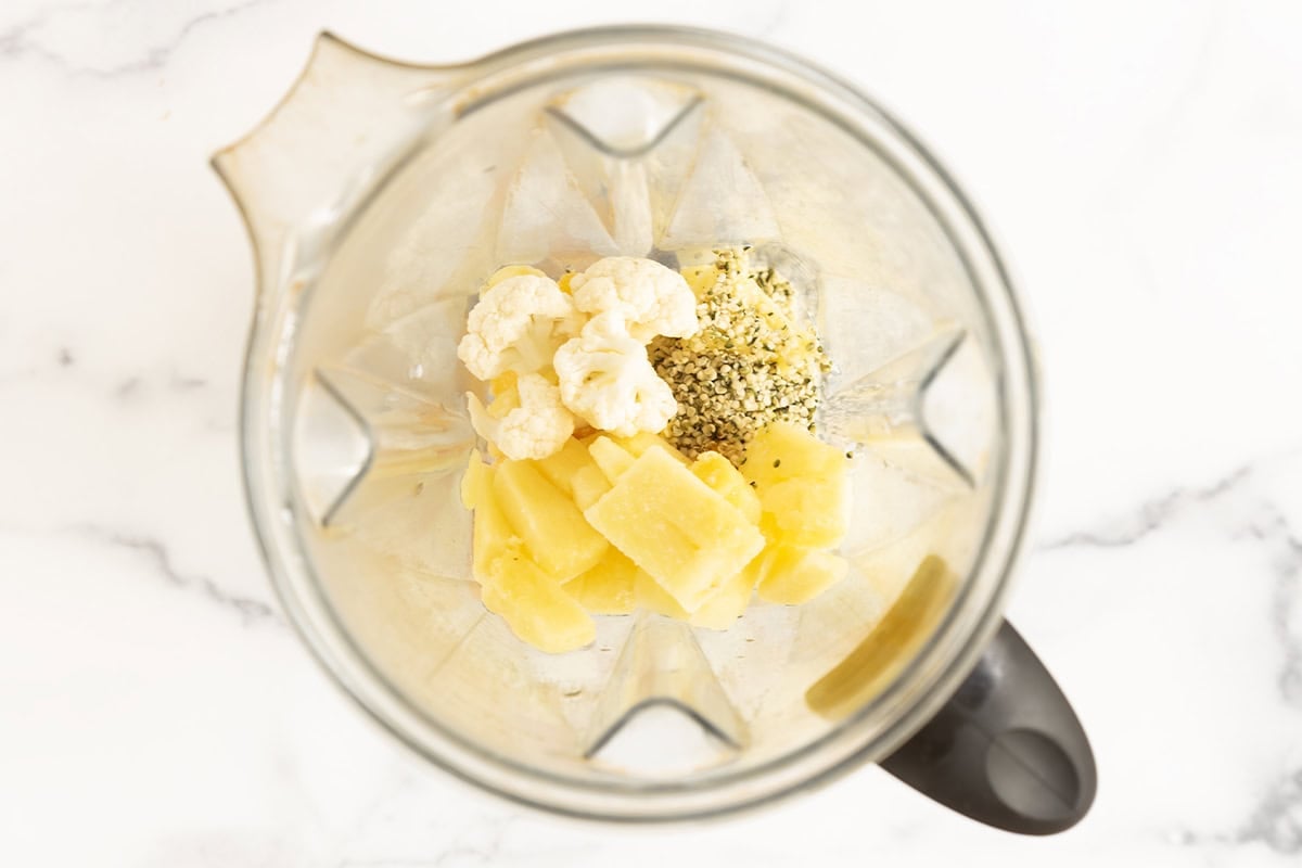 Pineapple, cauliflower, and hemp seeds in a blender.