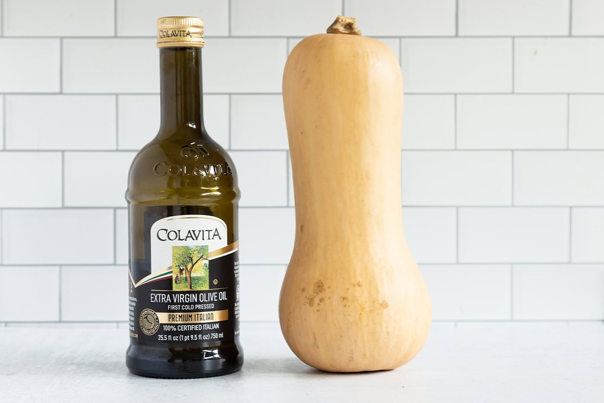 Butternut squash and olive oil on a counter.