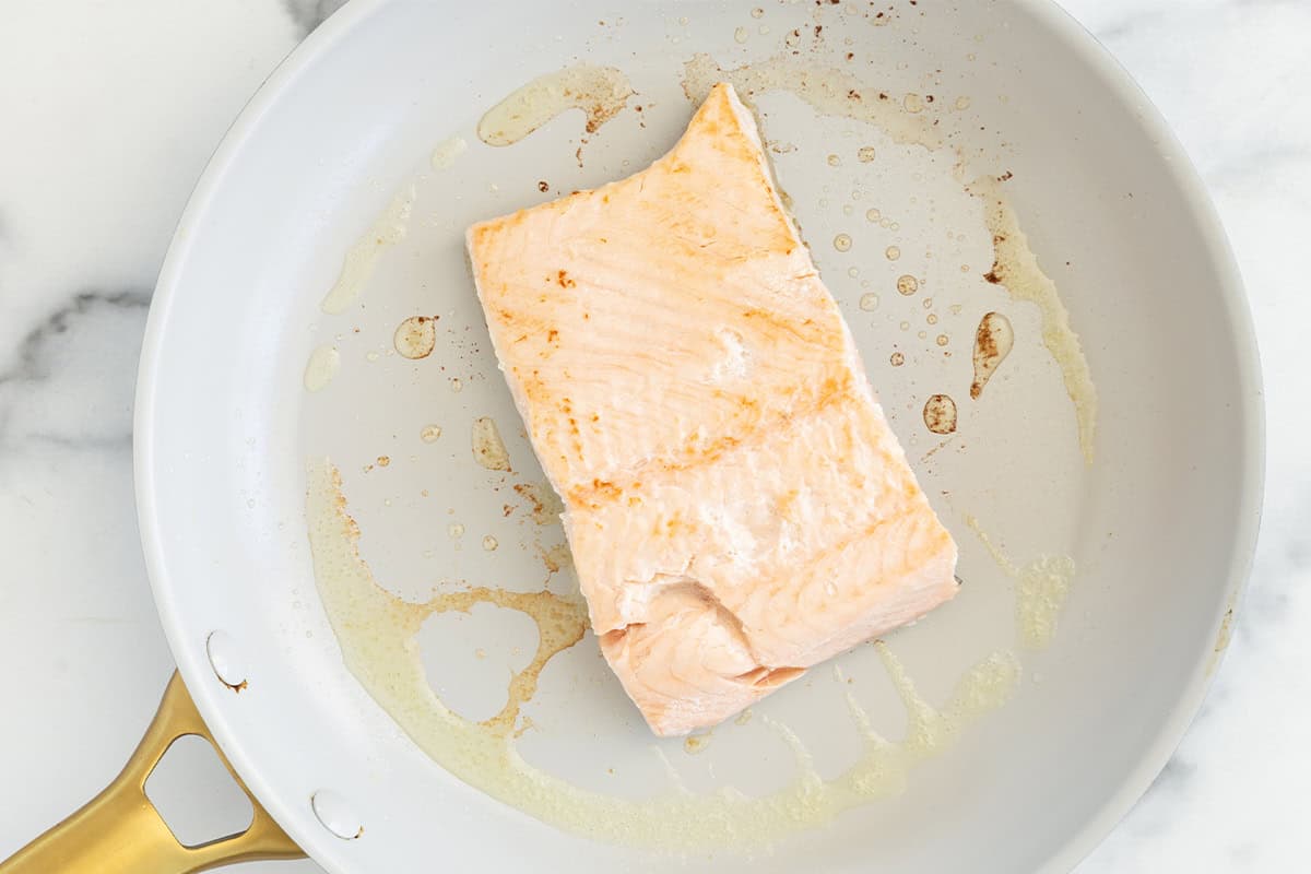 Cooked salmon fillet in a skillet.