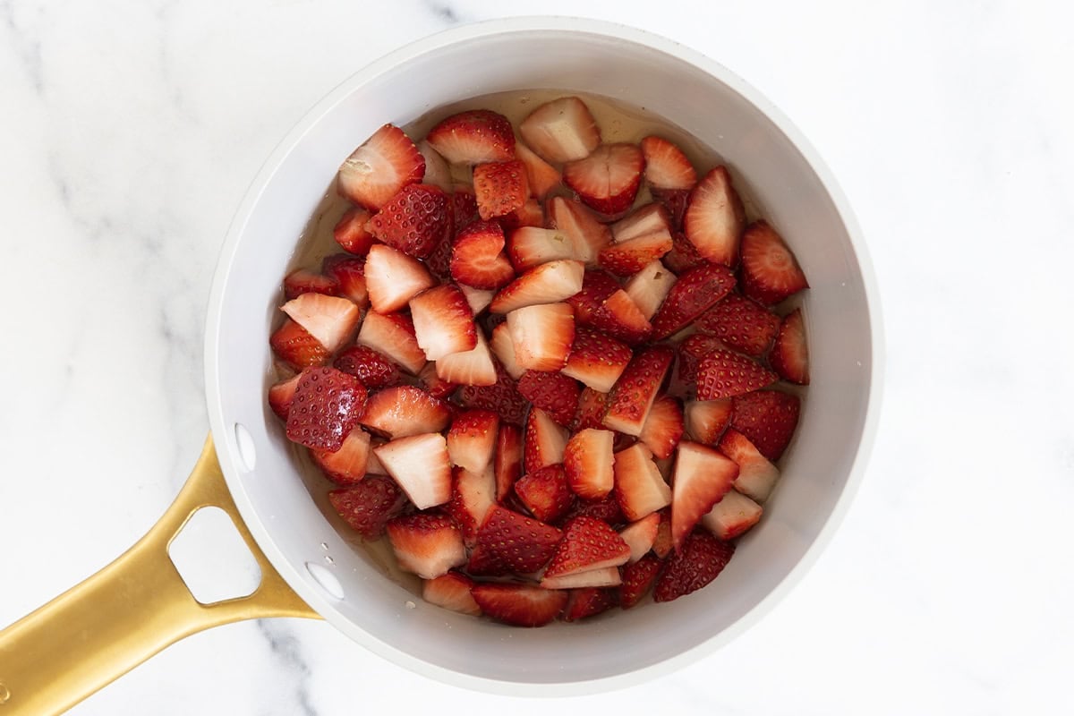 Chopped strawberries in a saucepan.