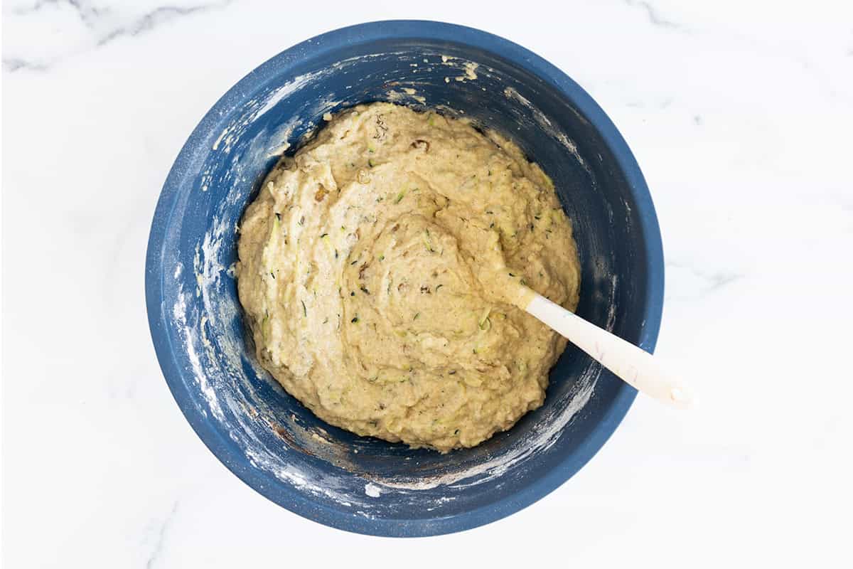 Zucchini cake batter in a blue bowl.
