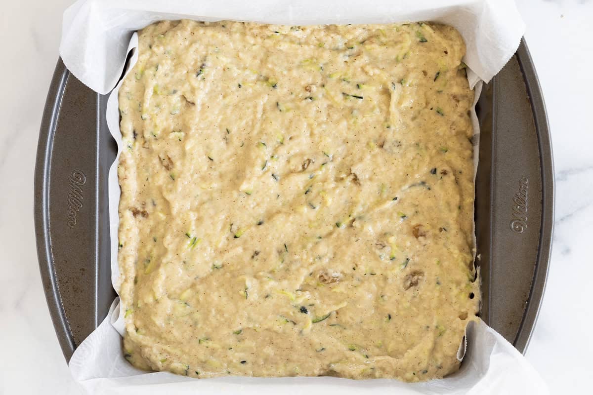 Zucchini cake batter in a prepared baking pan.